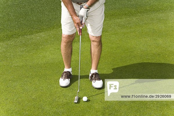 Detail eines Golfspielers beim Putten