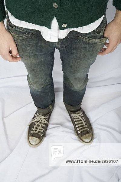 Ein junger Mann in Jeans und Canvas-Sneakers.