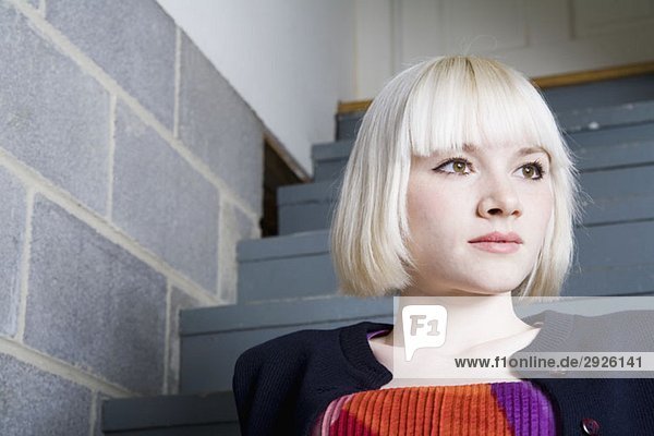 Eine junge Frau auf einer Treppe sitzend