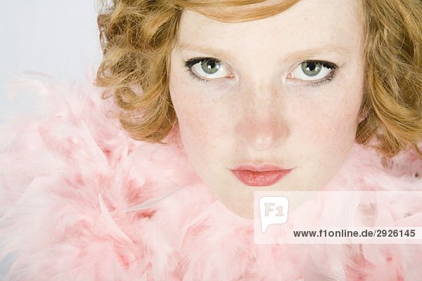 Porträt einer jungen Frau mit rosa Federboa