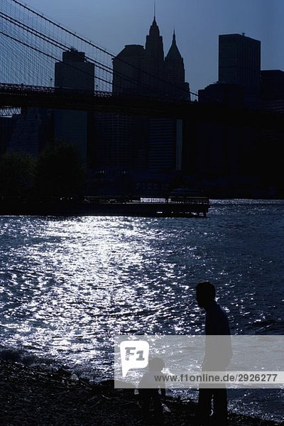 Silhouette der Menschen am East River und der Skyline von Manhattan  New York City