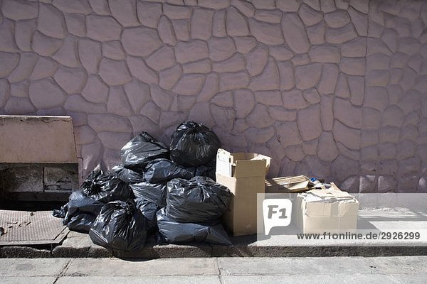 Kisten und Säcke mit Müll auf dem Bürgersteig