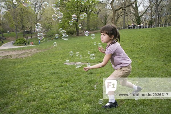 Ein junges Mädchen fängt Blasen im Central Park  New York City.
