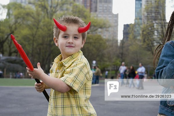 Ein Junge  der Teufelshörner trägt und eine Heugabel hält  Central Park  New York City