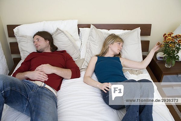 Ein junges Paar auf einem Bett liegend