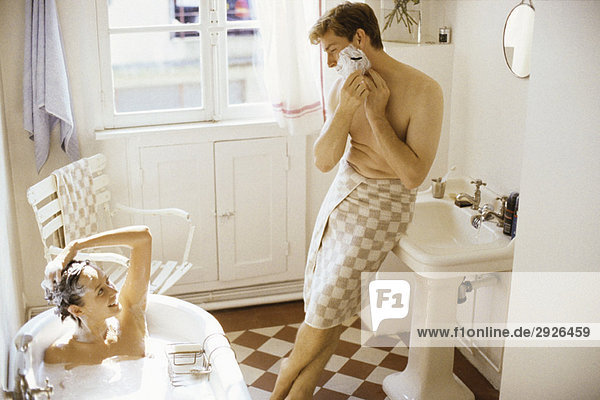 Paar zusammen im Bad  Frau badend  Mann an Waschbecken lehnend  rasierend