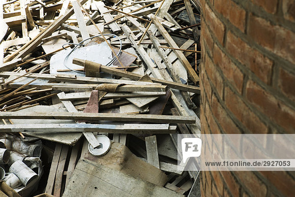 Haufen von Abbruchmaterial  Holz  Rohr  Drähte neben der Ziegelwand