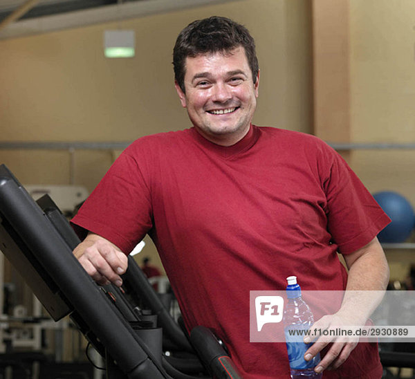 Mann entspannt sich auf Laufbändern im Fitnessstudio