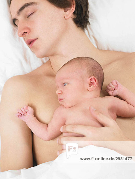 Vater schläft mit seinem Baby