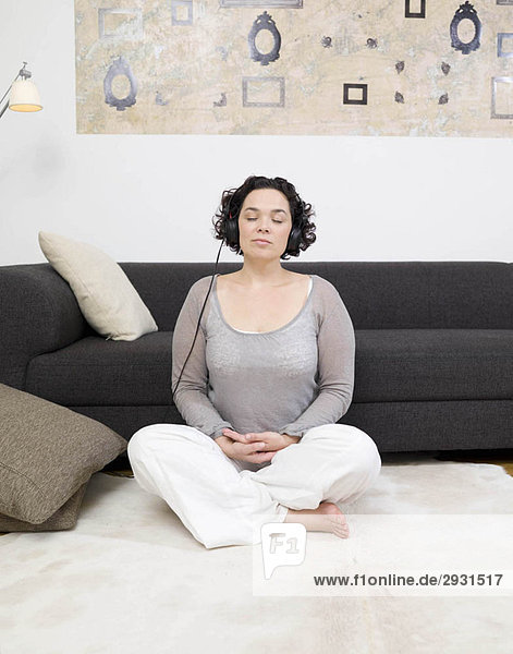 woman meditating  headphones on.