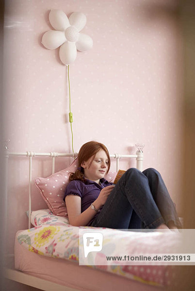Teenager-Mädchen liest im Schlafzimmer