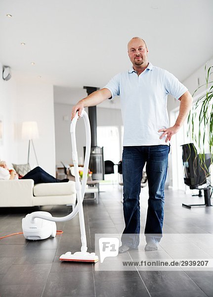 A man vacuuming a floor Sweden.