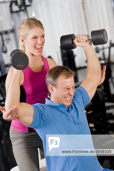 Ein Mann und eine Frau Krafttraining in einem Fitnessstudio Schweden.