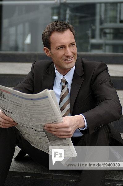 31-jähriger Business Mann im Anzug mit Zeitung