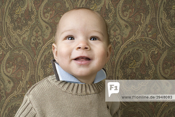 Portrait of a baby in front of a patterned background