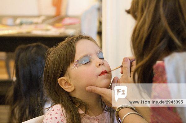 Ein kleines Mädchen immer Make-Up angewendet