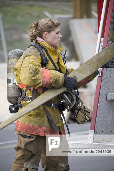 Weibliche Feuerwehrmann entfernen Schlauch aus Feuerwehrauto  Spokane  Washington