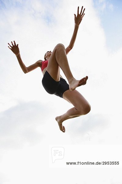 Junge Frau in die Luft springen