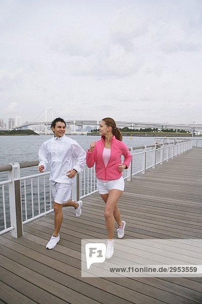 Young couple jogging on bridge