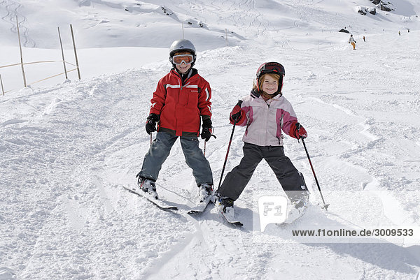 Two children skiing in the mountains