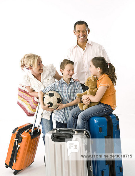 Family with two children with luggage  studio shot