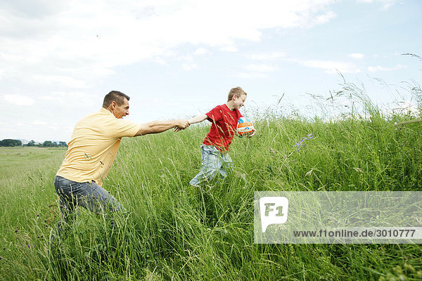 Father and son playing on a meadow