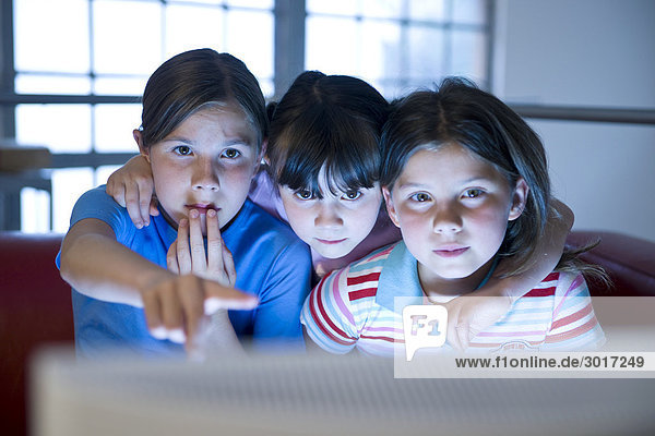 Drei Mädchen sitzen vor einem Computer  Frontal