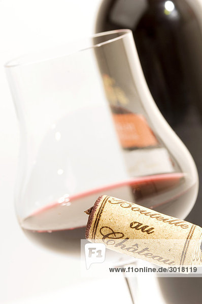 Rotweinglas und Korkenzieher vor Weinflasche  Close-up