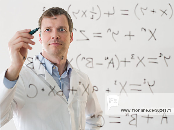 Male scientist working out a formula