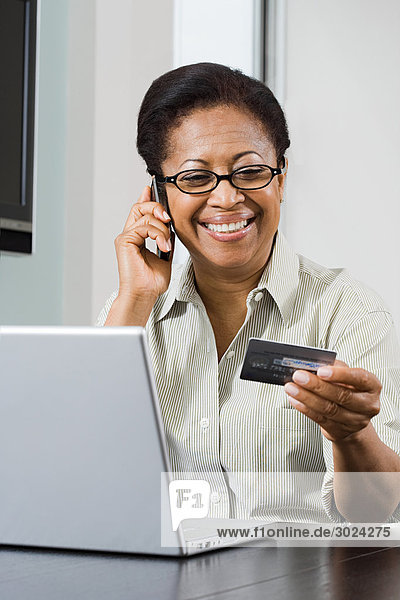 Woman with laptop cellphone and credit card