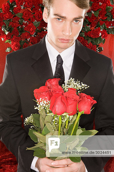 Ein Mann mit einem Strauß Rosen.