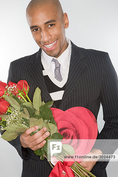 Lächelnder Mann mit einem Rosenstrauß