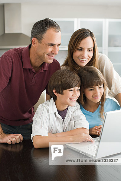 Familie  die einen Laptop benutzt