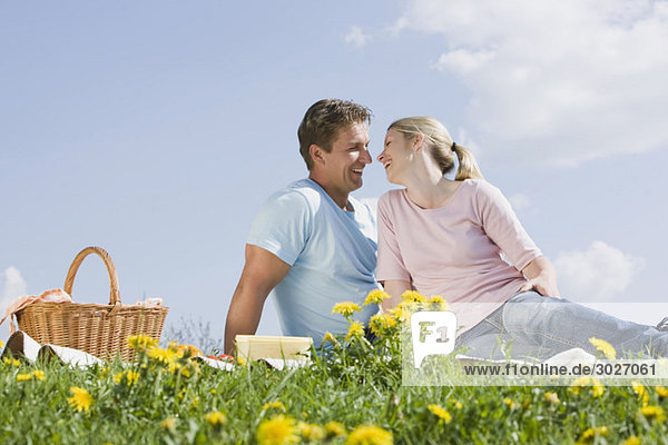 Germany  Bavaria  Munich  Couple having picnic  smiling at each other