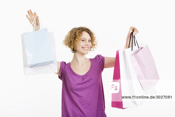 Junge Frau mit Einkaufstüten  lächelnd  Portrait