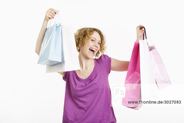 Junge Frau mit Einkaufstüten  lächelnd  Portrait