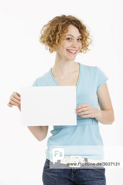 Junge Frau hält leeren Karton  lächelnd  Portrait
