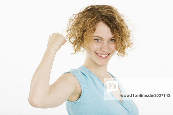 Young woman making fist  smiling  portrait