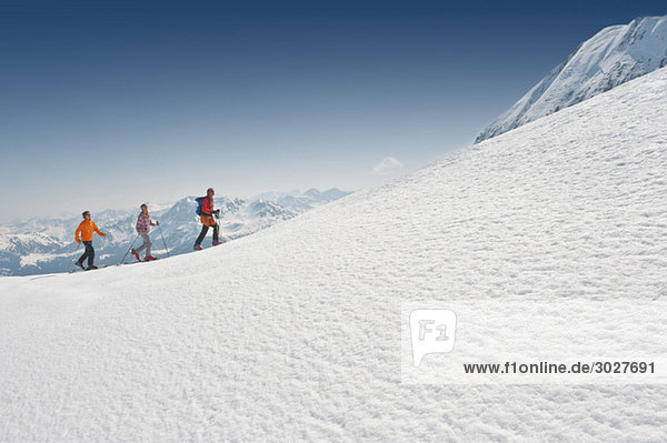 Austria,  Salzburger Land,  Altenmarkt,  Zauchensee,  Three persons cross country skiing in mountains,  side view