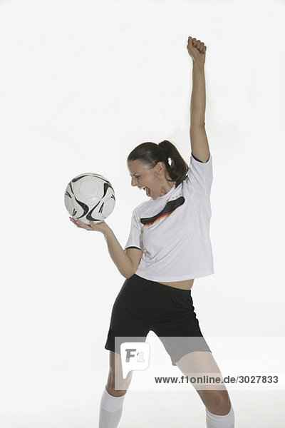 Portrait of a woman  holding soccer ball  cheering