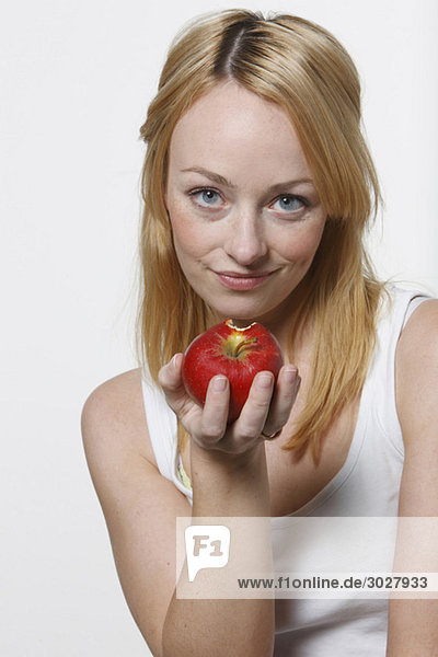 Junge Frau hält einen Apfel in der Hand