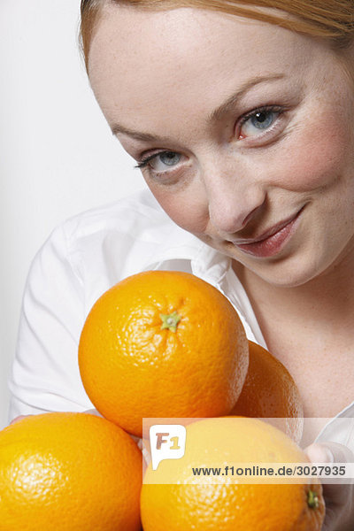 Junge Frau mit Orangen  lächelnd  Portrait
