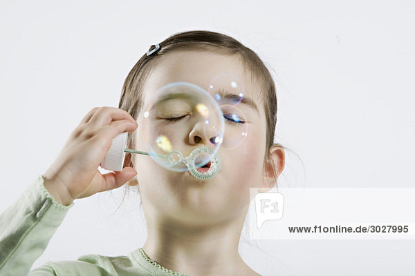 Girl (4-5) blowing bubbles  eyes closed  portrait  close-up