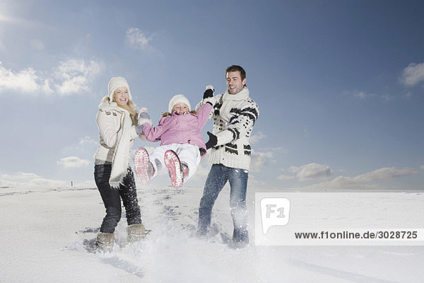 Deutschland  Bayern  München  Familie mit Tochter (6-7) in verschneiter Landschaft  Spaß haben