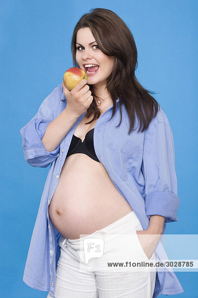 Pregnant woman holding apple  portrait