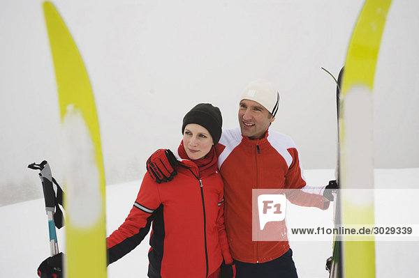 Italien  Südtirol  Paar in Winterkleidung  Ski im Vordergrund