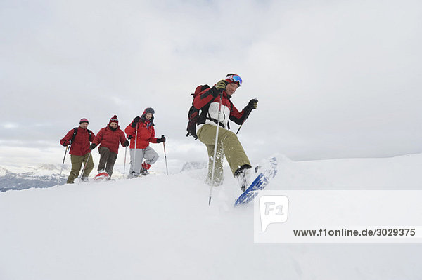 Italien  Südtirol  Vier Personen hintereinander  Schneeschuhwandern