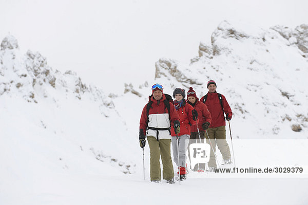 Italy  South Tyrol  Four people in a row  snowshoeing