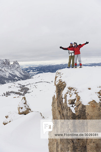 Italien  Südtirol  Paar in Winterkleidung auf dem Berggipfel  Jubelruf