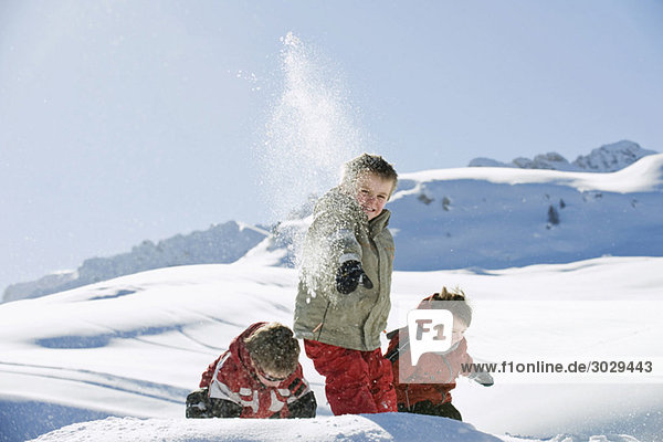 Italien  Südtirol  Seiseralm  Kinder werfen Schnee in die Luft
